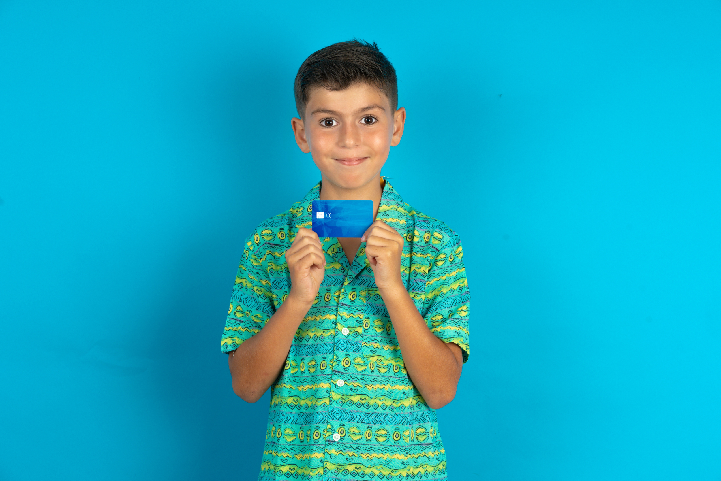 blue background, boy holding up a debit card